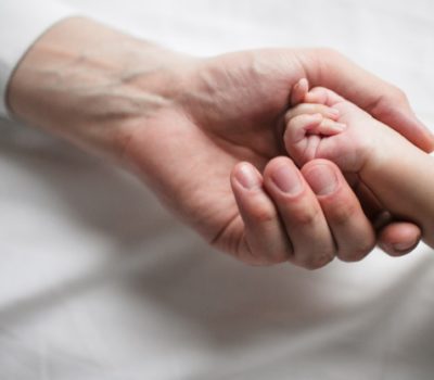 hand-of-woman-holding-baby-hand