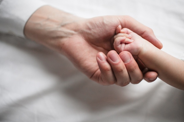 hand-of-woman-holding-baby-hand